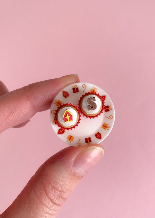 miniatuur sinterklaas cupcakes met mijter en chocolade letter op een wit bordje met sinterklaas afbeeldingen op de rand